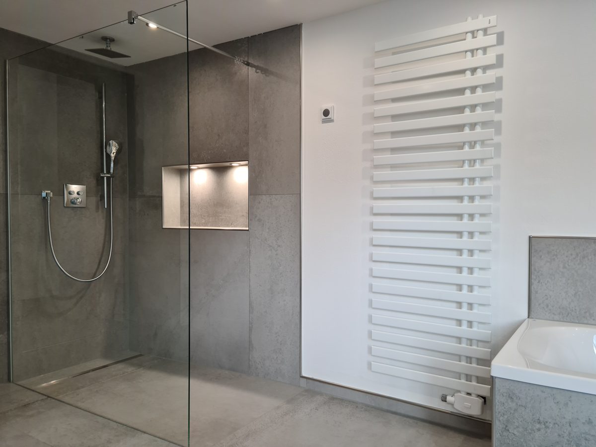 Duschbereich mit Glasabtrennung und Handtuchheizkörper